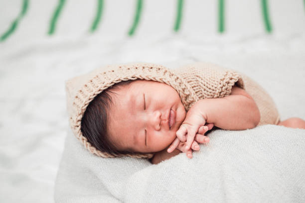 istock Adorable newborn baby peacefully sleeping on a white blanket. 1186291393