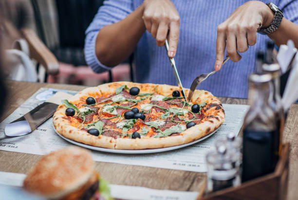 istock Lady eating pizza in pizzeria 1186292662