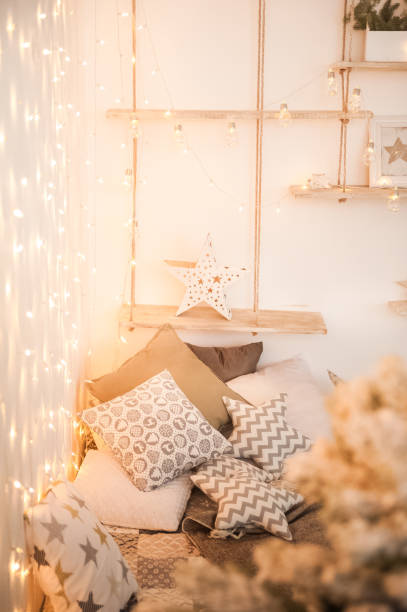 istock Rustic bedroom interior decorated for Christmas. New Year's interior Scandinavian style bed with pillows. Textural light room of a farmer's house with a Christmas tree and a garland. Background for text. 1186300049