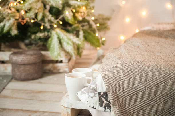 istock Rustic bedroom interior decorated for Christmas. New Year's interior Scandinavian style bed with pillows. Textural light room of a farmer's house with a Christmas tree and a garland. Background for text. 1186300057