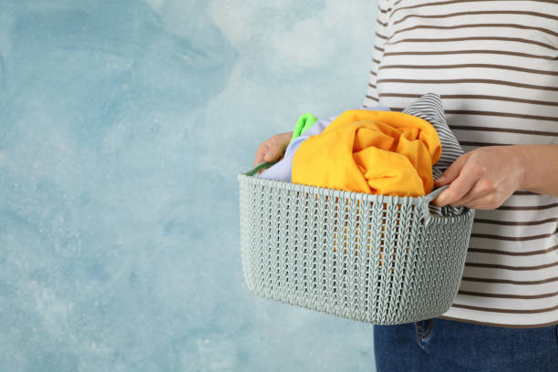 istock Young woman hold basket with clean clothes, space for text 1186300540