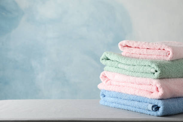 istock Stack of clean towels on ironing board, copy space 1186301216