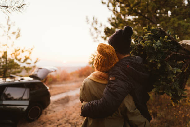 istock Couple carrying home their Christmas tree 1186301590
