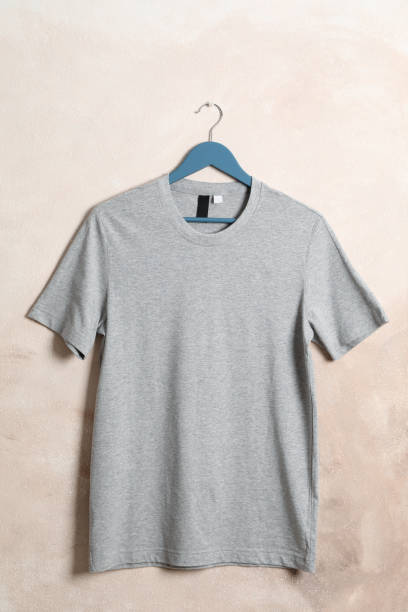 istock Hanger with blank gray t-shirt on light brown background, space for text 1186301625