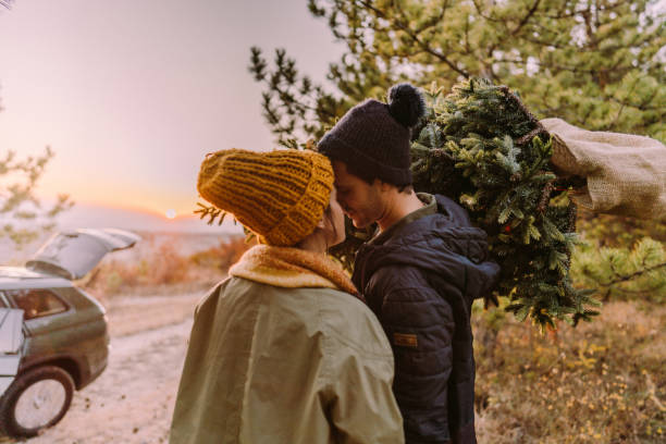 istock Happy couple carrying home their Christmas tree 1186301631