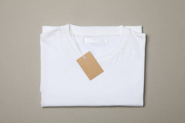 istock Folded blank white t-shirt with tag on gray background, space for text 1186301779