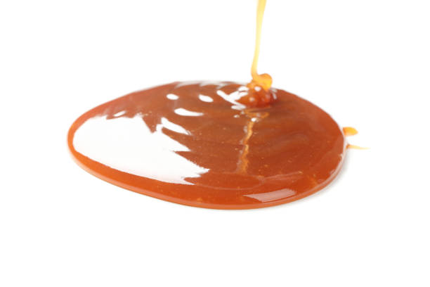 istock Pouring brown caramel isolated on white background 1186303169