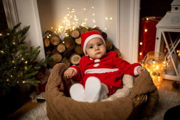 Beautiful baby girl  wearing Santa suit indoors at Christmas