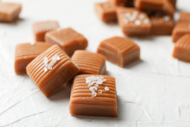 istock Salted caramel candies on white background, closeup and copy space 1186303379