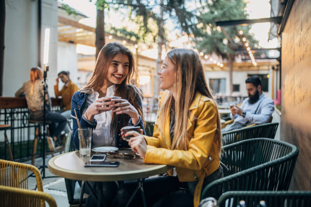 istock Young ladies sitting outdoors in cafe 1186314782