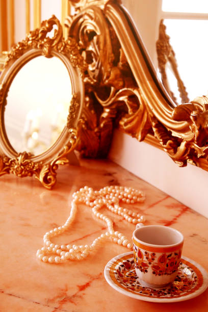 Boudoir. Table with antique mirror,  pearl necklace, cup and saucer