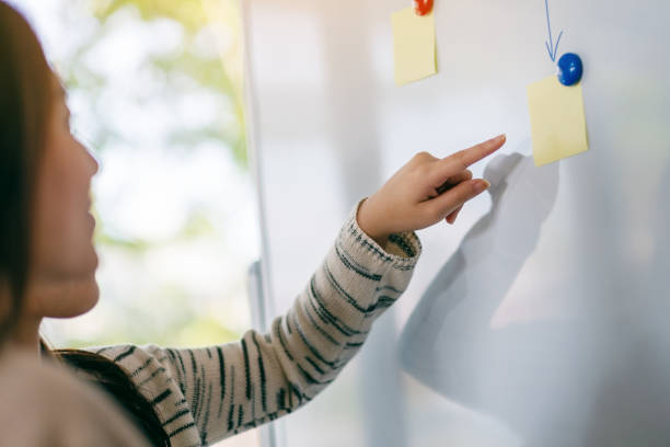 istock Business people looking, discussing and pointing finger at whiteboard 1186316051