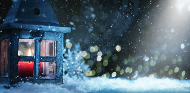 istock Lit Candle in the Christmas Lantern on Snow 1186316364