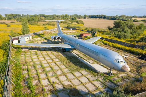 Aerial drone top view photo of abandoned passenger air plane in old airport no longer used. Ukraine Vasilkov