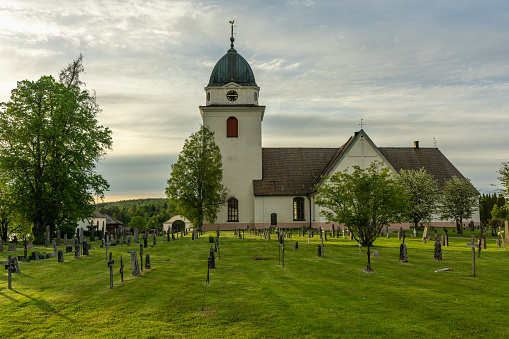 Antigua iglesia con un cementerio verde en el campo sueco photo