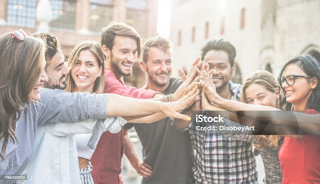 Diverse culture students stacking hands outdoor - Young happy people celebrating together - Youth, lifestyle, university, relationship, human resources, work and friendship concept - Focus on hands Strength Stock Photo