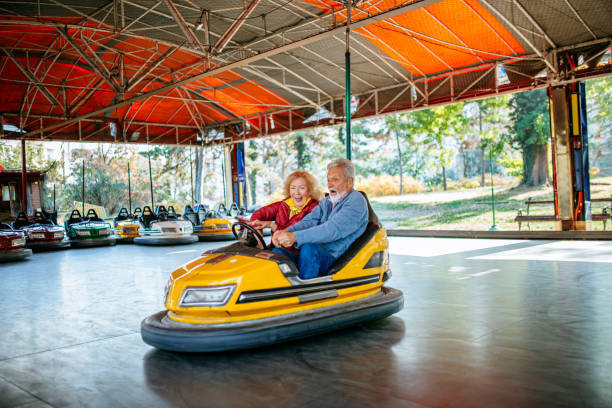 istock Amusement park - senior couple in bumper car 1186320961