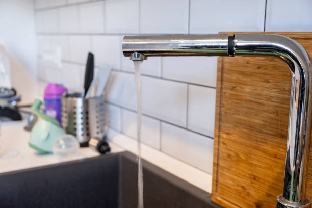 istock Kitchen sink and open water faucet Close Up 1186322964