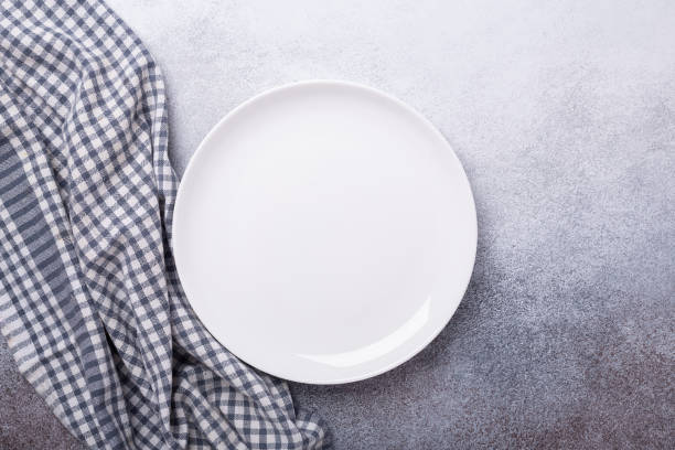 istock Empty white plate and linen napkin on stone background Copy space Top view 1186323782