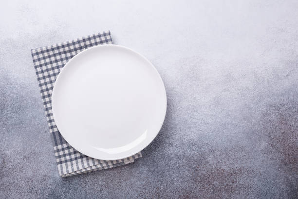 istock Empty white plate and linen napkin on stone background Copy space Top view 1186323805