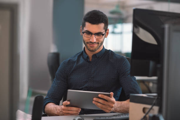 istock Young businessman using a tablet at his office desk 1186324970