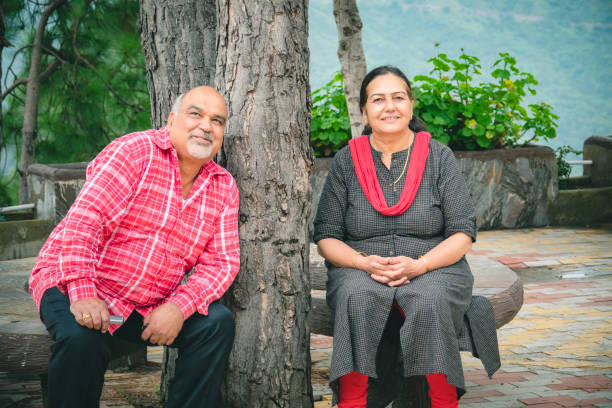 istock Retired, senior couple sits under tree at a resort in the mountains. 1186326094