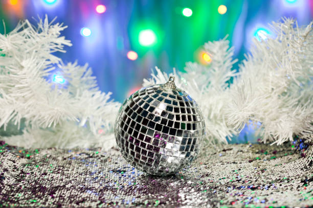 istock White fir branches and disco ball on a white sequin background 1186326142