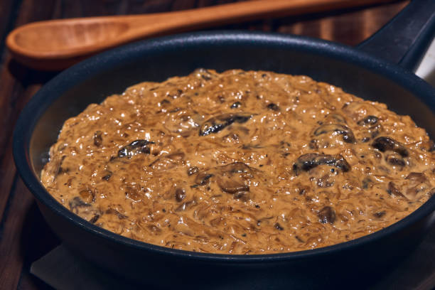 Panna e fungi suceHot pan with a delicious homemade creamy sauce made with sauteed champignon mushrooms, onions, extra virgin olive oil, soy sauce and spices. stock photo