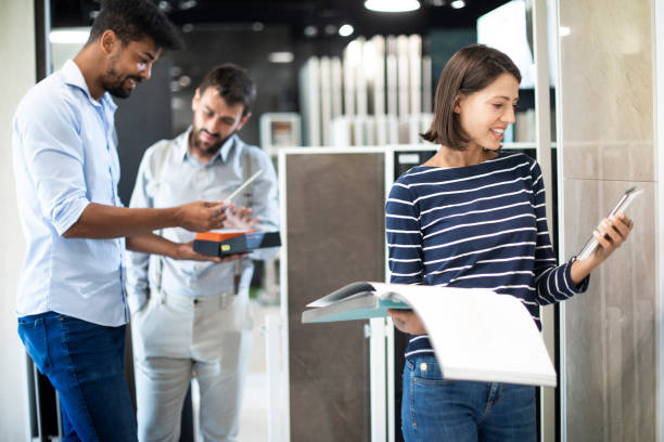istock Young woman making a decision while holding a tile sample and a catalog in her hand in a ceramics store 1186327095