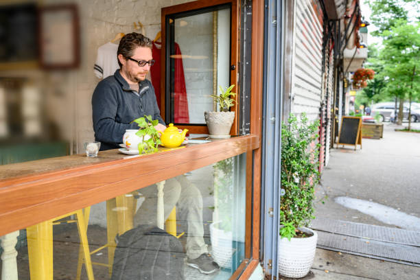 Man Drinking Tea at a Window Seat in a Brooklyn Cafe