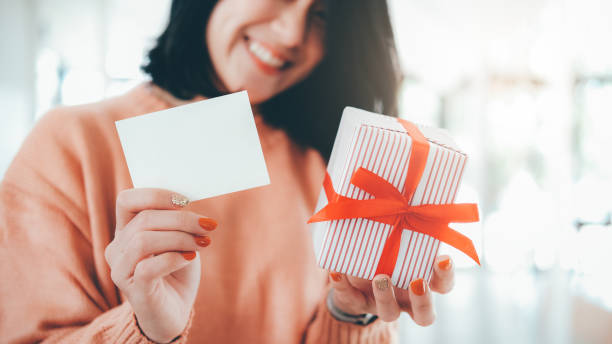 istock Woman holding white blank card and gift box. 1186331196