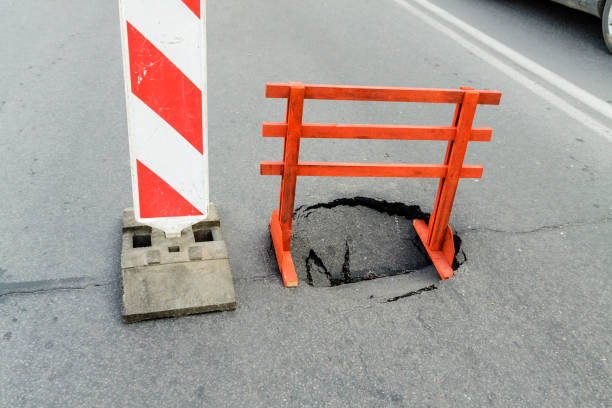 istock Warning sign and a hole on the road. Dangerous place. 1186331870