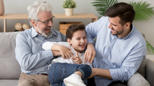 istock Happy three generation men family playing laughing tickling on sofa 1186336087