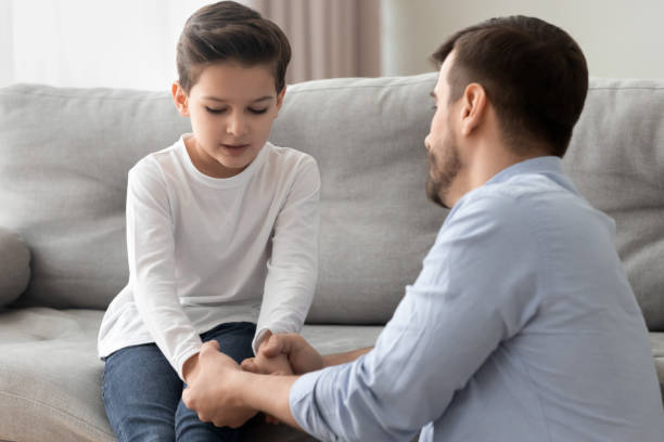 Worried single father comforting upset kid son helping with problem Worried loving young single father holding hand talking comforting upset little kid son sharing helping with problem, caring dad foster parent give support apologizing supporting listening child boy single father stock pictures, royalty-free photos & images