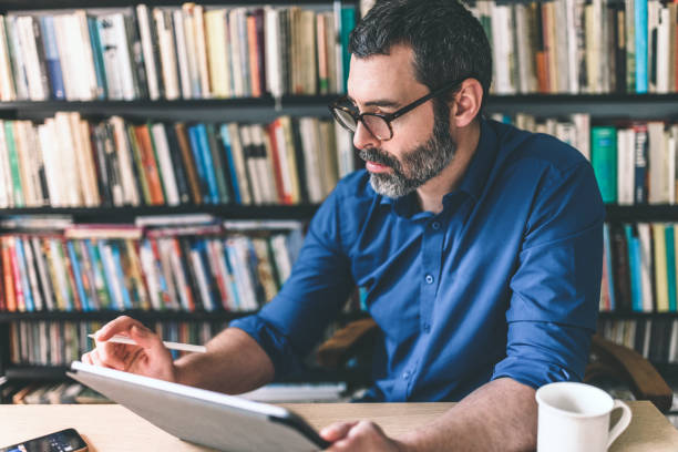 istock bearded business man checking checking business stats at digital tablet 1186337509
