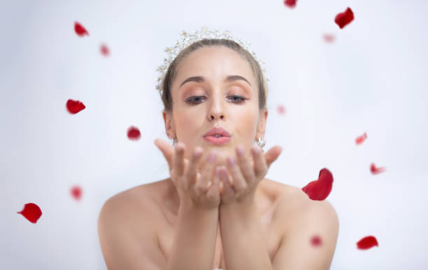 istock Bride Blowing Rose Petals Against White Background 1186341835