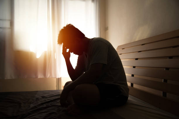 istock Depressed Man Sitting On Bed At Home 1186342064
