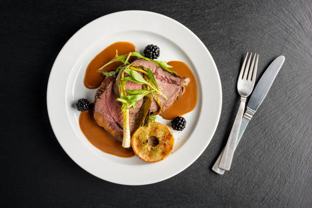 Venison with apple and seasonal vegetables. Overhead dish of venison with apple and seasonal vegetables. Colour, horizontal with some copy space, photographed on location at a restaurant on the island of Moen in Denmark. gravy photos stock pictures, royalty-free photos & images
