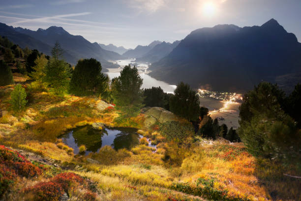 Silvaplana in Switzerland is a beautiful chain of reservoirs surrounded by picturesque rocky peaks. High-altitude lake Hahnensee in the starlight under the moon