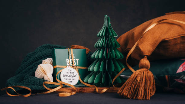 Christmas still with christmas gift and tree with home textiles \nSoft home interior gifts arrangement