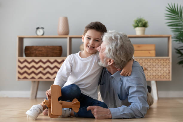 istock Happy old grandad embracing cute small grandson looking at camera 1186352929