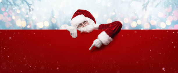 istock Santa Claus Showing Something On a Red Wall 1186353055