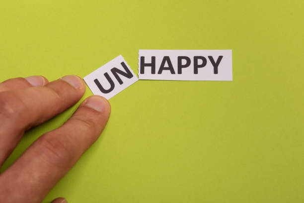 istock man hand holding card with text unhappy, cutting word 'un' so it written 'happy'. Copy space. Lime background. Studio shoot 1186353301