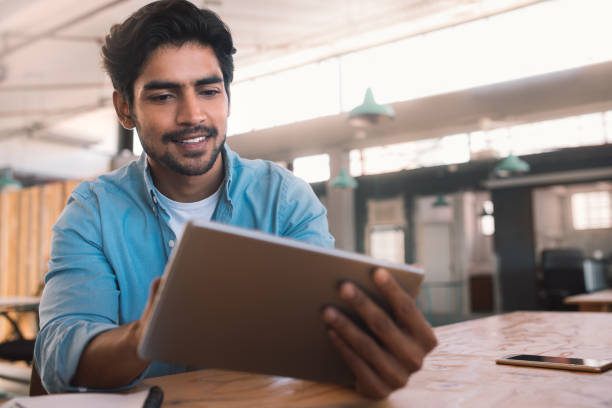 istock Smiling young businessman working on a tablet in an office 1186356753
