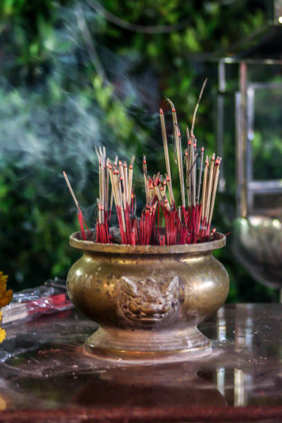 istock burning incense sticks in vase on the table. Decorative elements of the cafe, blur and grain effect. 1186357028