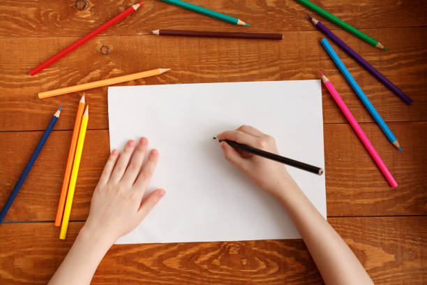 istock Child's hands with pencil view from above 1186359647