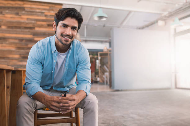 istock Smiling young businessman sitting in a bright modern office 1186360179