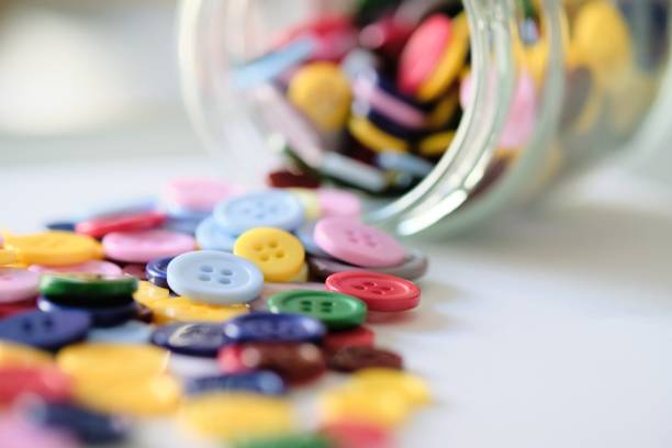 Large Group Of Colorful Plastic Sewing Buttons In A Can On Table, With Copy Space For Text
