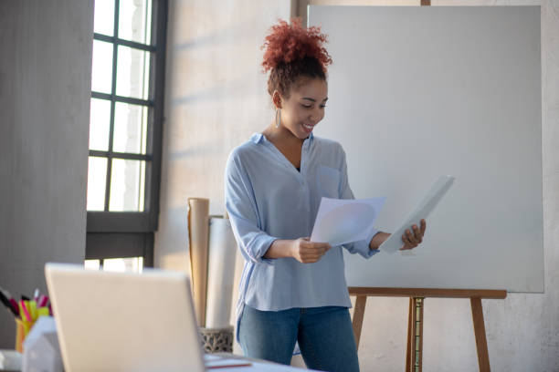 istock Designer standing near drawing easel and looking at sketches 1186364213