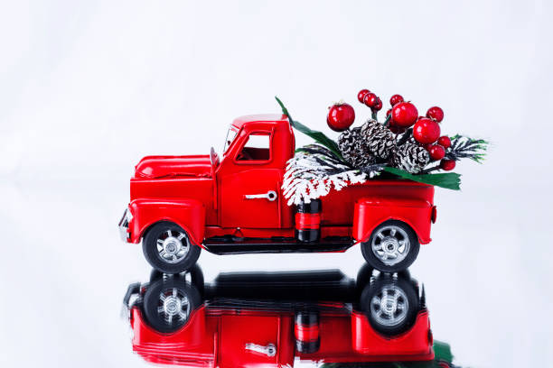 świąteczny bukiet z jagodami w czerwonej świątecznej ciężarówce na białym tle, odbijany na lustrzanej powierzchni. koncepcja - kartka z życzeniami na boże narodzenie i nowy rok, dostawa świąteczna. kopiuj miejsce - pick up truck truck toy figurine zdjęcia i obrazy z banku zdjęć